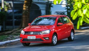 Volkswagen Gol, líder entre os carros mais vendidos do Brasil em agosto, na cor vermelha, em movimento em rua ensolarada