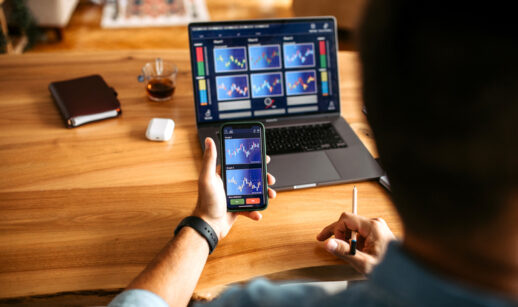 Homem com celular na mão conferindo dados financeiros