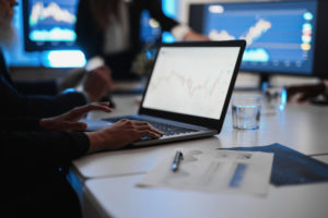 Investidor analisa gráficos do mercado financeiro em um computador