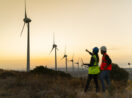 Engenheiros diante de torres eólicas