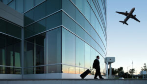 passageiro com mala e avião passando no céu