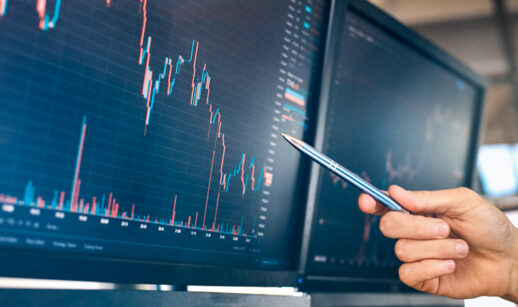 mão apontando para a linha de um gráfico na tela, alusivo ao desempenho de uma empresa para um follow-on ou subscrição